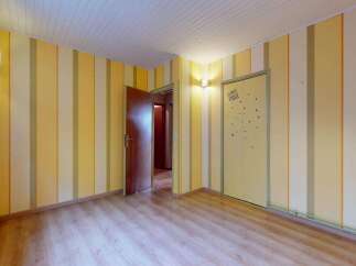 Step into a charming room featuring vibrant yellow and white striped wallpaper, creating a playful and inviting atmosphere.