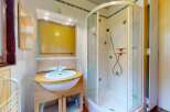 This bathroom features a spacious corner shower with a frosted glass enclosure and decorative tile accents.