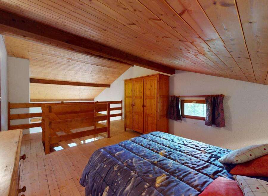 Discover this charming attic bedroom featuring a cozy double bed with a celestial-themed duvet, perfect for a restful night's sleep.