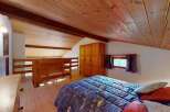 Discover this charming attic bedroom featuring a cozy double bed with a celestial-themed duvet, perfect for a restful night's sleep.