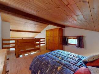 Discover this charming attic bedroom featuring a cozy double bed with a celestial-themed duvet, perfect for a restful night's sleep.