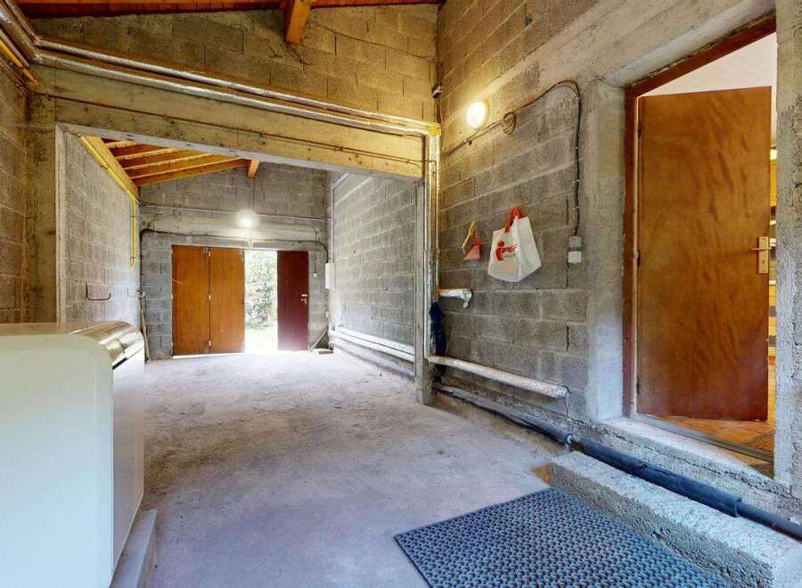 Discover this versatile space featuring a durable concrete floor and robust cinder block walls, perfect for a workshop or storage area.
