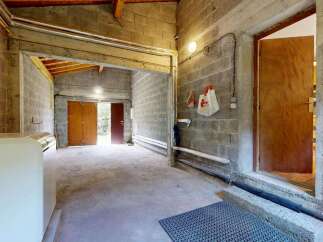 Discover this versatile space featuring a durable concrete floor and robust cinder block walls, perfect for a workshop or storage area.