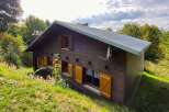 Nestled amidst lush greenery, this charming wooden chalet offers a serene mountain retreat.