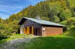 Discover this charming wooden cabin nestled amidst a lush, green forest, perfect for a serene getaway.