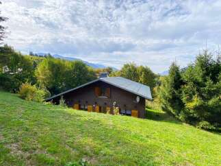 Nestled amidst lush greenery and rolling hills, this charming wooden chalet offers a serene mountain retreat.