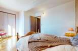 This charming bedroom features a comfortable bed adorned with a cozy brown blanket and a decorative pillow.