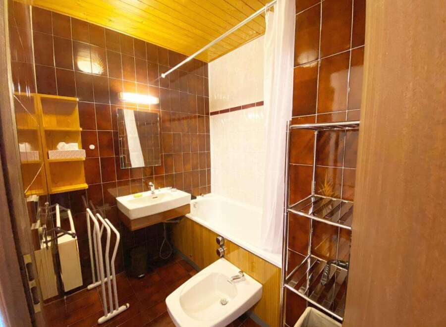 This charming bathroom features a classic white bathtub with a shower curtain, perfect for relaxing after a long day.