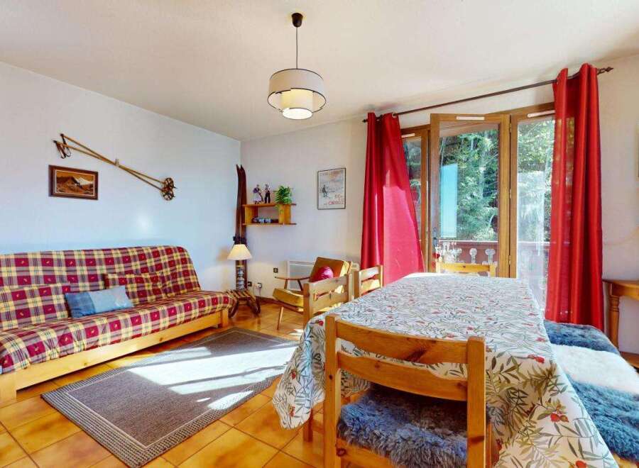 Experience cozy mountain living in this charming apartment, featuring a vibrant plaid sofa and a dining area perfect for family meals.