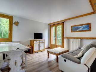This cozy living room features a rustic wooden dining table with benches, perfect for family meals.