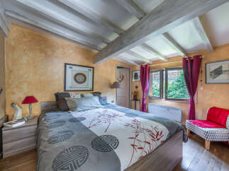 This charming bedroom features a cozy bed with a unique duvet cover showcasing a bamboo and geometric pattern.