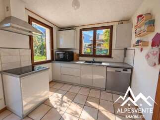 This charming kitchen boasts modern white cabinetry and a sleek induction stovetop, perfect for culinary enthusiasts.