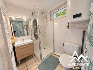 This bathroom features a modern vanity with ample storage, a spacious glass-enclosed shower, and a convenient toilet.