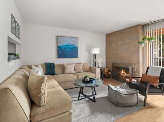Cozy up by the fireplace in this inviting living room, featuring a plush sectional sofa perfect for relaxation.