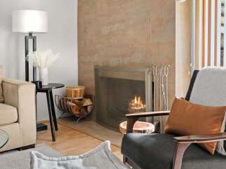 Cozy up by the modern fireplace, featuring a warm, tiled surround and a protective screen.