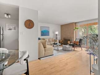 Step into this inviting living space, featuring a cozy fireplace and ample natural light streaming through large windows.