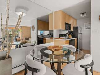 This modern condo features a sleek open-concept living space with a stylish dining area and a well-equipped kitchen.