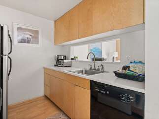 Discover this charming kitchen featuring sleek, light wood cabinetry that offers ample storage.