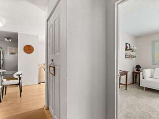 Step into a welcoming entryway featuring a charming wooden clock and a decorative 'Welcome' sign.