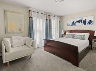 Experience comfort and style in this beautifully appointed bedroom, featuring a king-sized bed with plush bedding and decorative pillows.