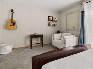 This cozy bedroom features a comfortable white sofa, perfect for relaxing.