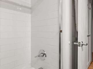 This modern bathroom features a pristine white subway tile shower and a deep soaking tub, perfect for relaxation.