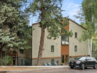 Discover this modern residence featuring a stucco exterior and warm wood accents, offering a contemporary aesthetic.