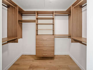 Step into this spacious walk-in closet, featuring a modern design with ample storage solutions.