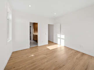 Step into this bright and airy bedroom, featuring a large window that floods the space with natural light.