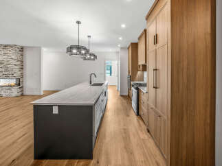 Experience modern living in this stunning open-concept home, featuring a sleek kitchen with a large island and ample cabinet space.