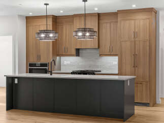 Experience modern luxury in this stunning kitchen, featuring sleek wood cabinetry and a spacious island with a dark gray finish.