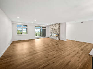 Experience breathtaking views from this spacious living area, featuring a modern gas fireplace with a stone accent wall.