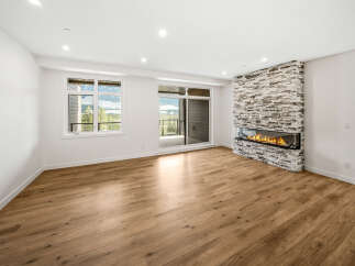 Experience modern living in this spacious room featuring a stunning linear fireplace with a stacked stone surround, perfect for cozy evenings.