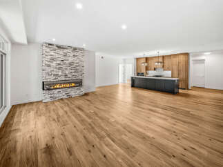 Experience modern living in this spacious open-concept home, featuring a stunning stone-clad fireplace as a focal point.