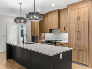 Experience modern luxury in this stunning kitchen, featuring a sleek dark island topped with exquisite marble countertops.