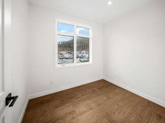 Step into this bright and airy room, featuring a large window that floods the space with natural light and offers scenic views of the surrounding landscape.