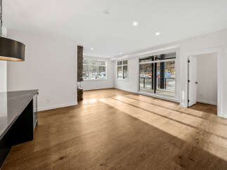 Experience modern living in this spacious open-concept great room, featuring a striking stone fireplace and abundant natural light.