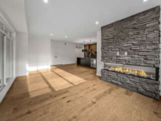 Experience modern living in this spacious open-concept home, featuring a stunning double-sided gas fireplace with a stacked stone surround as the centerpiece.
