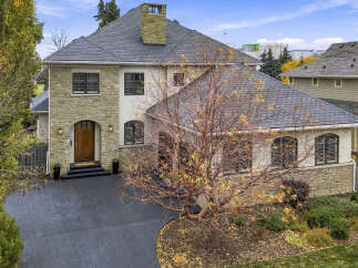This stunning home boasts a sophisticated exterior with a combination of stone and stucco finishes, complemented by a durable slate roof.