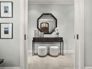 Step into a welcoming entryway featuring a sleek dark wood console table topped with decorative vases and a delicate orchid.