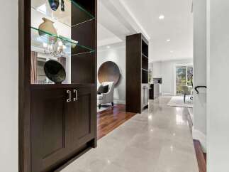 Step into a beautifully designed living space featuring elegant dark wood cabinetry with glass shelving, perfect for displaying decorative items.