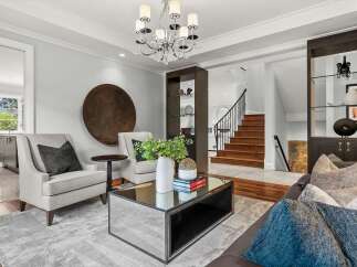 Step into this elegant living room, featuring plush seating and a striking mirrored coffee table, perfect for entertaining.