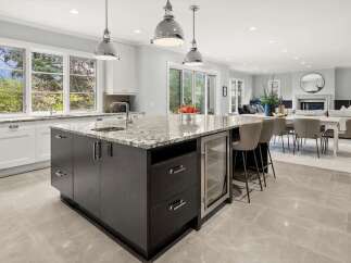 Experience luxury and functionality in this stunning open-concept kitchen, featuring a spacious granite island with a built-in wine cooler and ample seating.