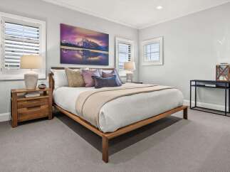 This serene bedroom features a comfortable king-size bed with plush pillows and a cozy throw blanket, perfect for relaxation.