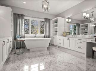 Experience luxury in this spacious master bathroom, featuring a freestanding soaking tub positioned perfectly by a large window for a spa-like retreat.