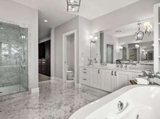 Experience luxury in this stunning master bathroom, featuring a spacious marble-tiled shower and a freestanding soaking tub.