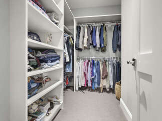Step into this impeccably organized walk-in closet, featuring ample shelving and hanging space for all your wardrobe needs.