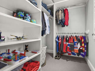 Discover this meticulously organized closet, featuring ample shelving for toys and accessories, including a fun soccer game and building blocks.