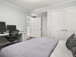 This bedroom offers a functional workspace with a modern desk and ergonomic chair, perfect for remote work or study.