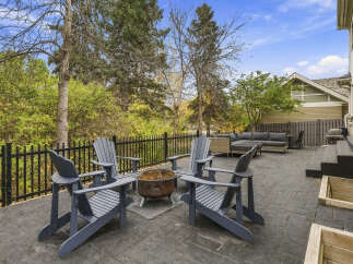 Enjoy outdoor living on this spacious stone patio, complete with a fire pit and comfortable seating.